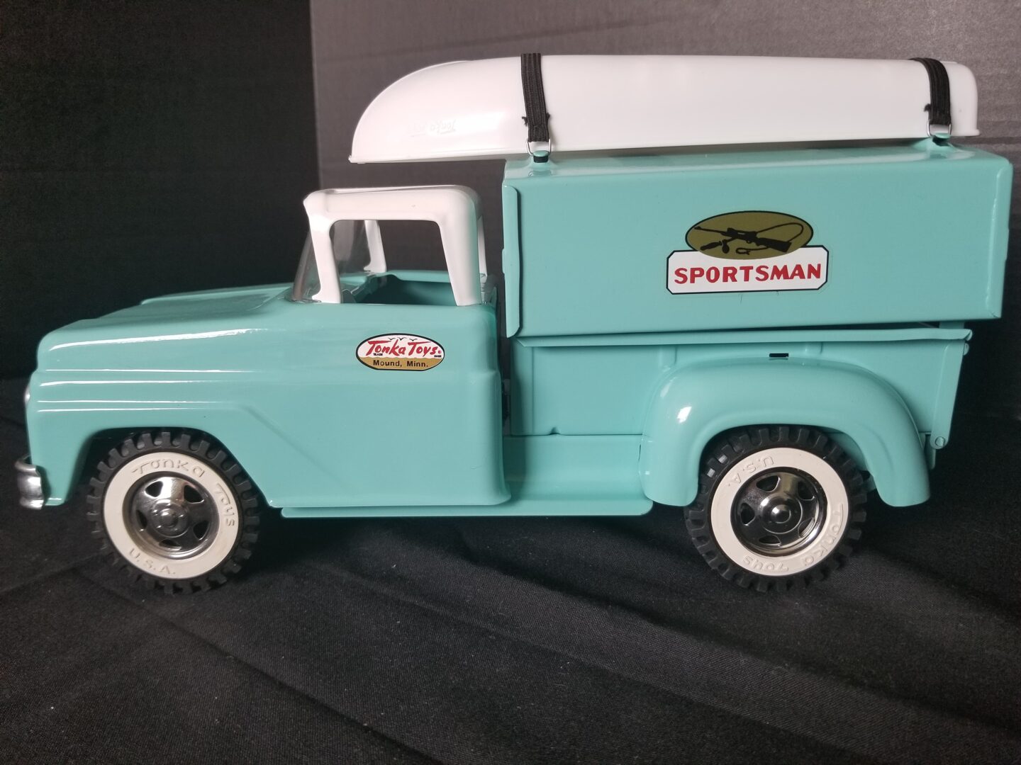 A toy truck with a surfboard on the side.